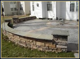 Stamped Ashlar Slate Patio with Stone Walls and Custom Artwork